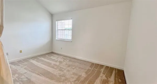 a view of an empty room with wooden floor and stairs