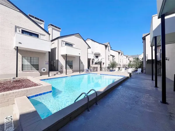 front view of a house with large trees and furniture