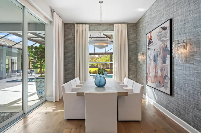 a kitchen with stainless steel appliances kitchen island granite countertop a table chairs and a refrigerator