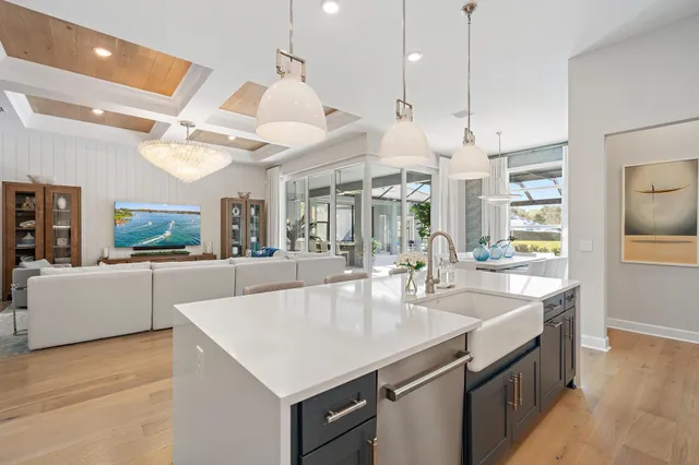 a spacious bedroom with a bed a chandelier and large window