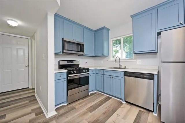 a view of a kitchen with wooden floor and a ceiling fan
