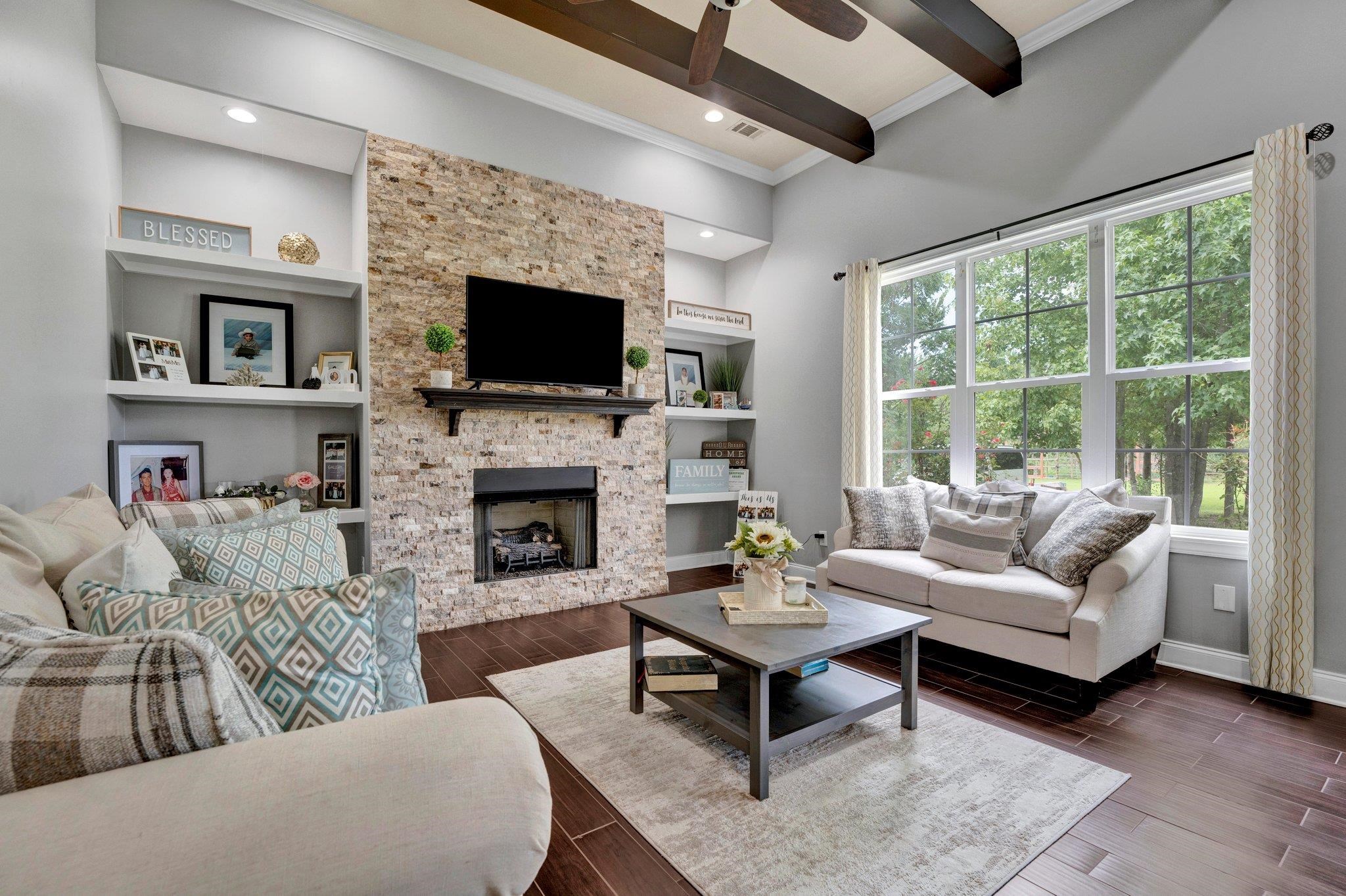 3270 Rast Road Millington, TN 38053 - Photo 17 of 40 Living area featuring beamed ceiling, dark wood-style floors, a ceiling fan, a large fireplace, and built in features