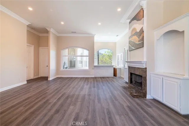 a view of a livingroom with wooden floor and a fireplace