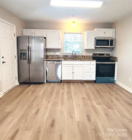 a kitchen with stainless steel appliances a refrigerator sink and microwave