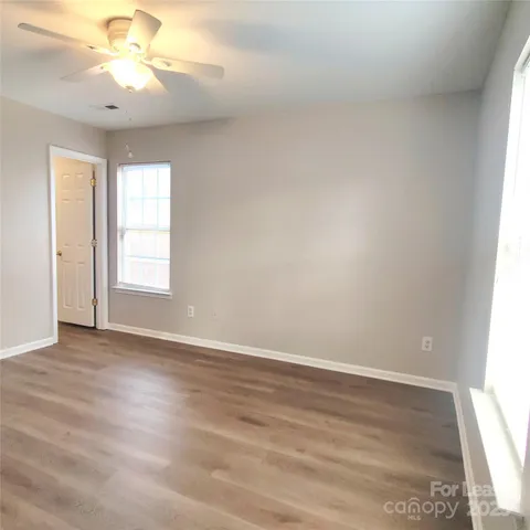 an empty room with a window and a ceiling fan