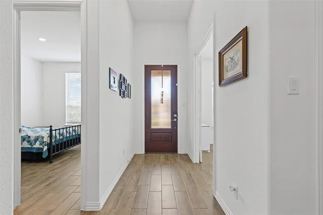 a view of a hallway with wooden floor and a bedroom