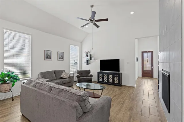 a living room with furniture a fireplace and a flat screen tv