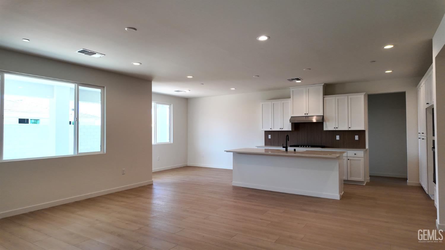 Undisclosed Address Bakersfield, CA 93311 - Photo 2 of 31 a kitchen with stainless steel appliances kitchen island granite countertop a refrigerator a sink a stove and white cabinets with wooden floor
