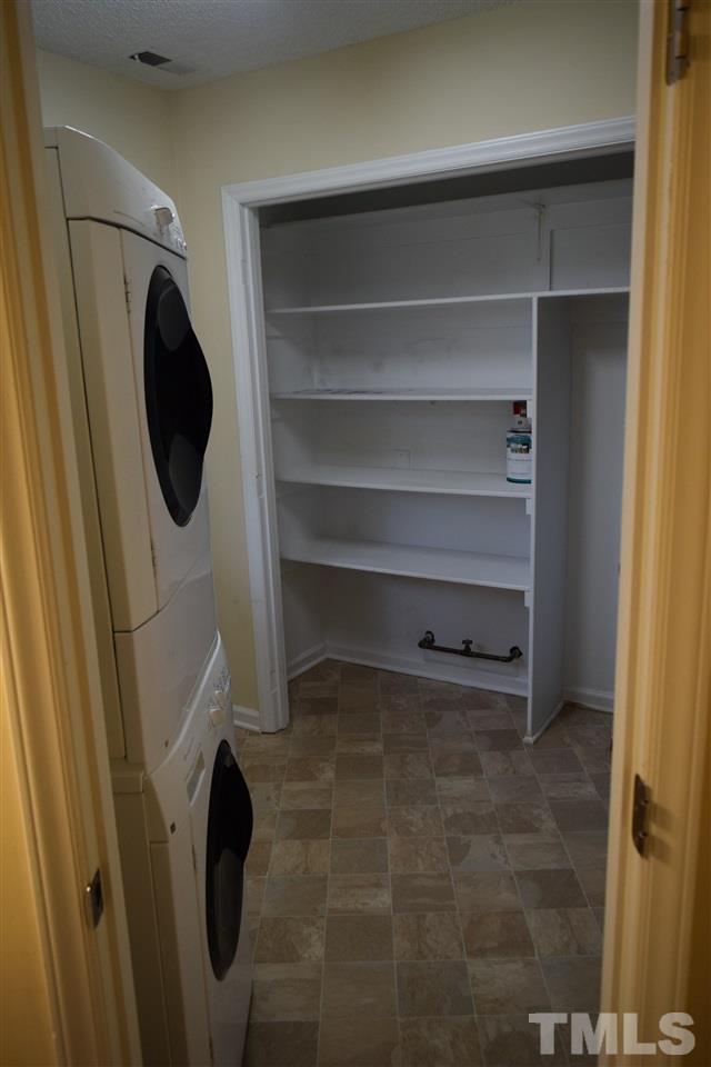 6617 Cassam Road Bahama, NC 27503 - Photo 11 of 20 The laundry room, although compact, has a stacked washer and dryer and shelving for more storage.