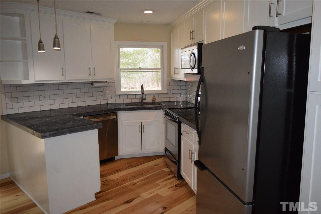 6617 Cassam Road Bahama, NC 27503 - Photo 6 of 20 The kitchen is in the corner of the great room and features subway tiles and stainless steel appliances.