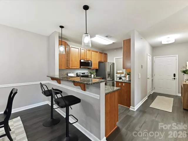 a kitchen with stainless steel appliances kitchen island granite countertop a refrigerator a stove a sink dishwasher with a dining table and chairs