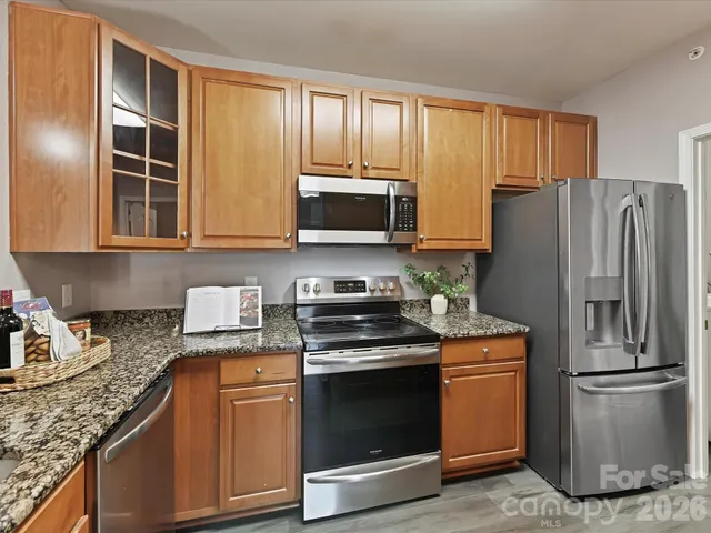 a kitchen with granite countertop a refrigerator stove and microwave