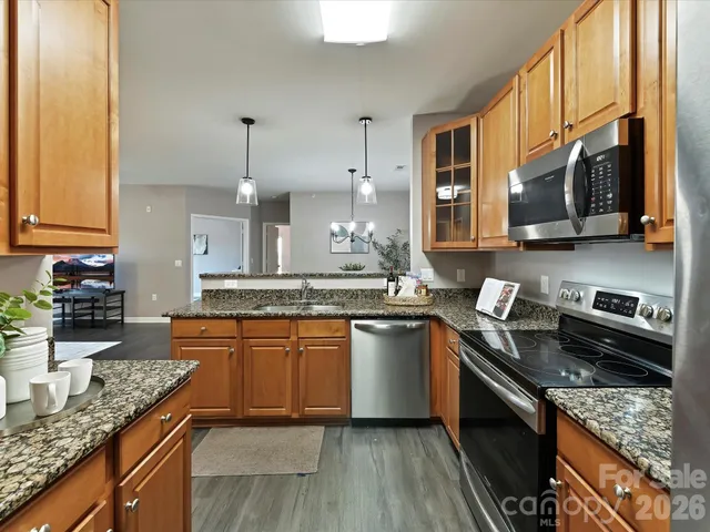 a kitchen with stainless steel appliances granite countertop a stove a sink and a granite counter tops