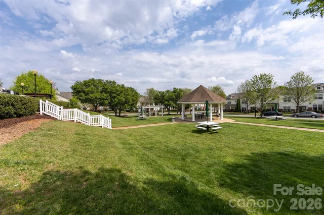 a white house with a big yard and large trees