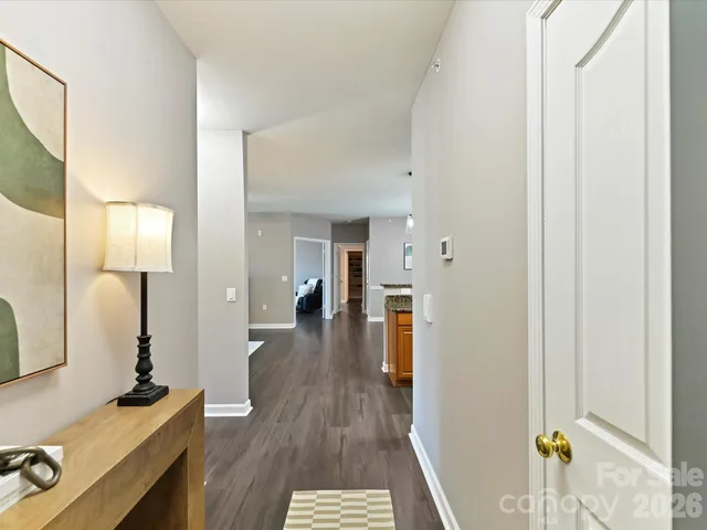 a view of a hallway with wooden floor windows and a livingroom