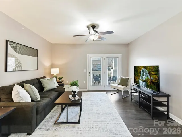 a living room with furniture a rug and a flat screen tv