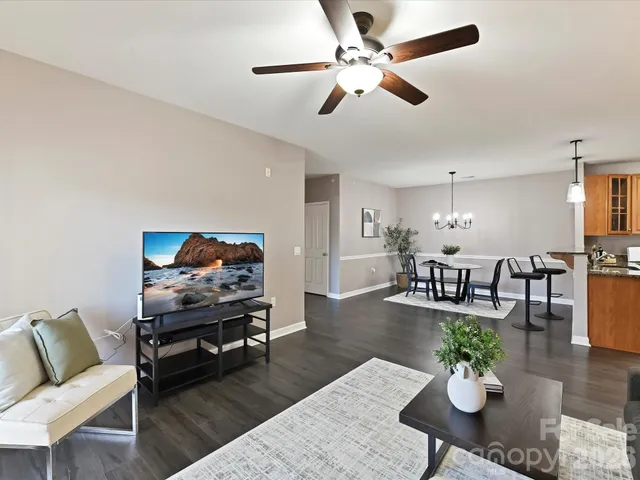 a living room with furniture potted plant and a dining table