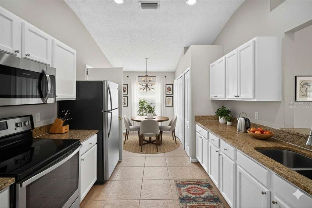 12630 Early Run Lane Riverview, FL 33578 - Photo 2 of 14 a kitchen with stainless steel appliances a refrigerator stove microwave and sink