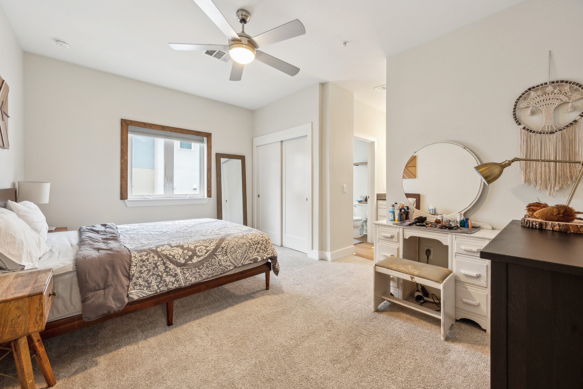 2827 Manor Road, Unit 3104 Austin, TX 78722 - Photo 12 of 30 A well-lit bedroom with soft carpeting and a clear passage to a private bathroom.