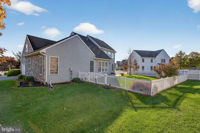 a view of a house with a small yard and a large tree