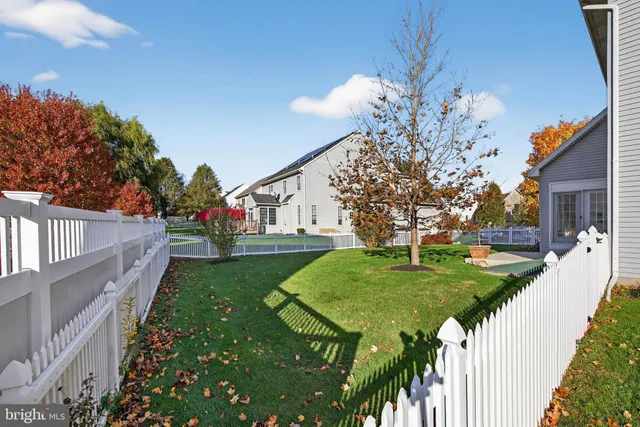 a house that is sitting in a big yard with large trees