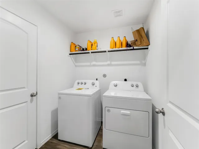 a view of a hallway with wooden floor and a bathroom