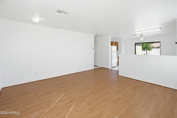 a view of empty room with wooden floor and window