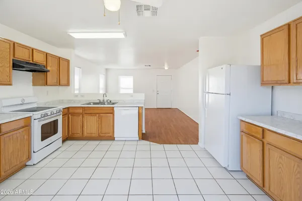 a kitchen with a stove a sink dishwasher and a refrigerator