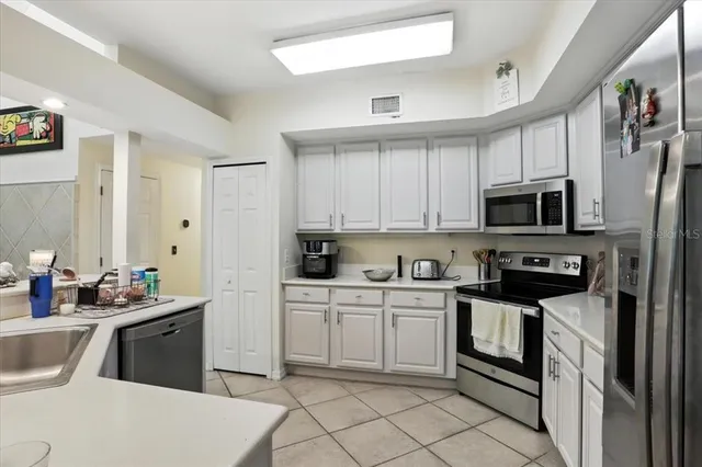 a kitchen with stainless steel appliances a sink stove refrigerator and cabinets