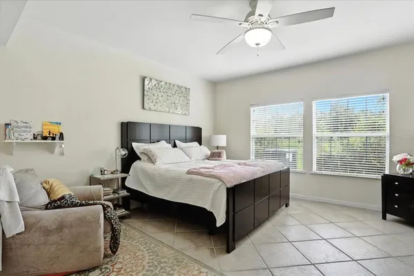 a spacious bedroom with a bed and a chandelier