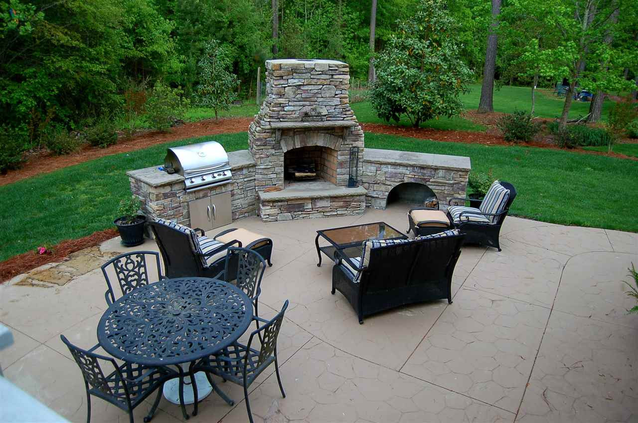 8111 Henderson Road Apex, NC 27539 - Photo 24 of 25 Imagine late evening cookouts on this beautiful patio with stone fireplace and built in grill outdoor fireplace and patio