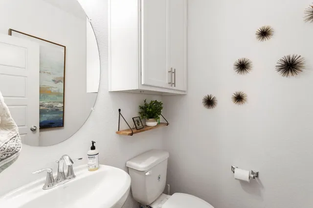 a bathroom with a sink a toilet and mirror