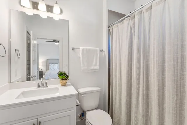a bathroom with a sink a toilet and shower curtain