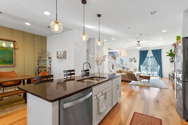 a kitchen island with granite countertop a sink cabinets and living room view