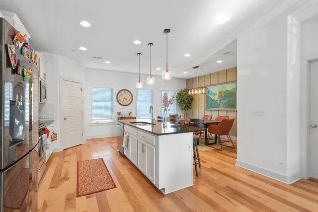 a kitchen with stainless steel appliances granite countertop a stove and a wooden floors