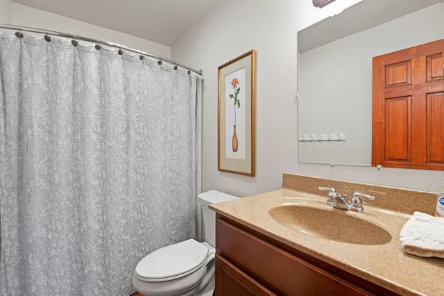 a bathroom with a granite countertop sink toilet and shower