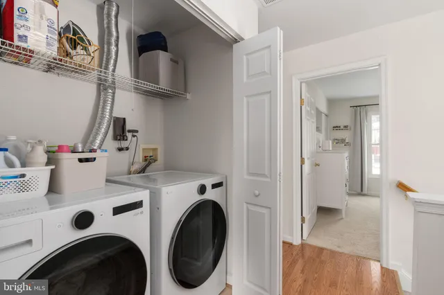 a view of a hallway with a couch and a bathroom with sink