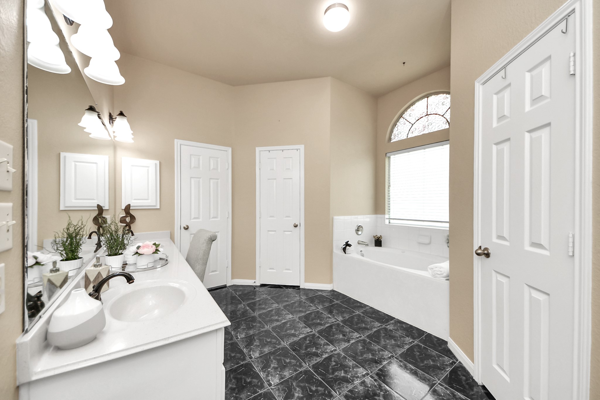 19123 Center Park Drive Spring, TX 77373 - Photo 25 of 42 a en suite bathroom with a double vanity sink a mirror and a bathtub
