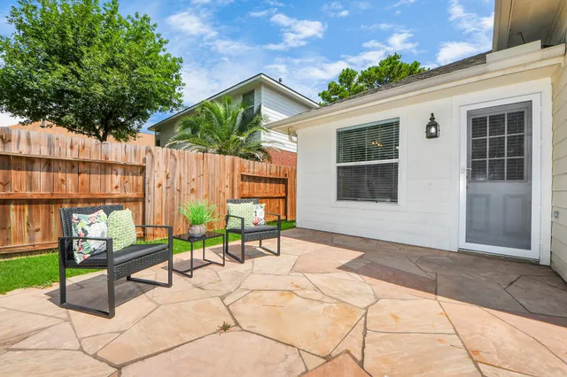 a view of a house with backyard and sitting area