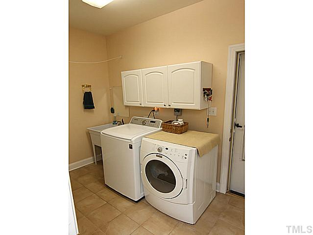 3805 Evander Way Raleigh, NC 27613 - Photo 20 of 23 The main floor laundry has a walk-in closet with storage behind, cabinets and a utility sink, conveniently located off the garage.