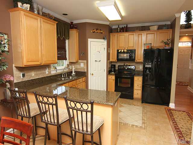3805 Evander Way Raleigh, NC 27613 - Photo 4 of 23 Enjoy the delicious smells of the kitchen, sitting at the breakfast bar. A walk-in pantry and provides extra storage. Granite counters newer appliances including new dishwasher accent the maple cabinets.