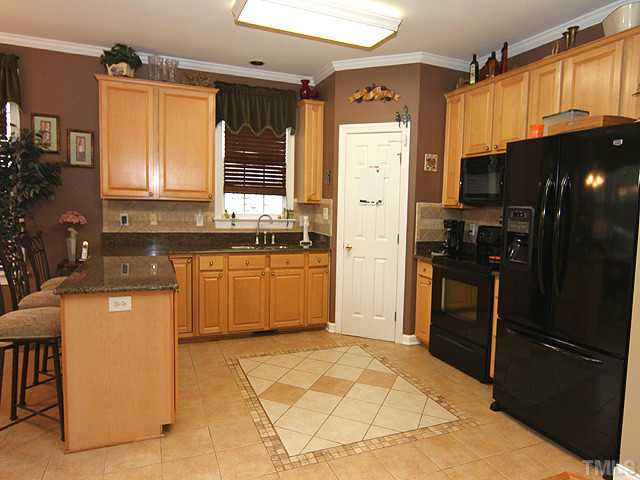 3805 Evander Way Raleigh, NC 27613 - Photo 5 of 23 Decorative tile flooring and tile back splash finish off the kitchen.