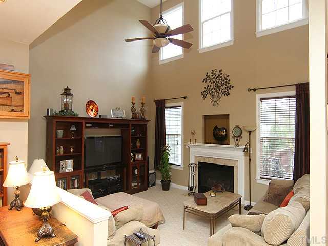 3805 Evander Way Raleigh, NC 27613 - Photo 8 of 23 The 2-story family room with gas fireplace, ceiling fan and lots of windows is open to the kitchen.