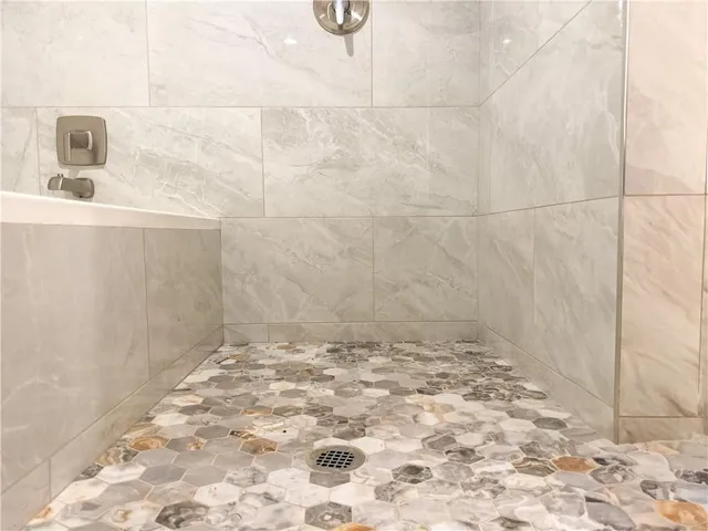 a bathroom with a white bath tub and a shower