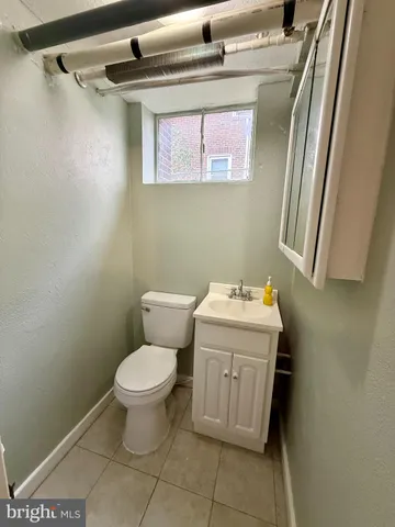 a bathroom with a sink a toilet and a mirror