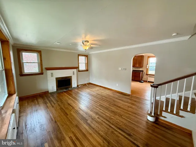 a view of empty room with fireplace and wooden floor