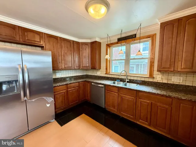 a kitchen with stainless steel appliances granite countertop a sink a stove and a refrigerator