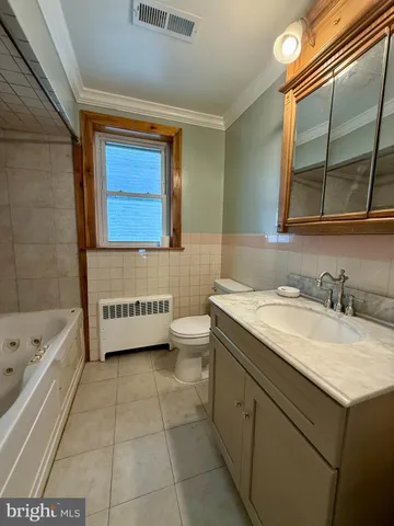 a bathroom with a granite countertop sink a toilet mirror and bathtub