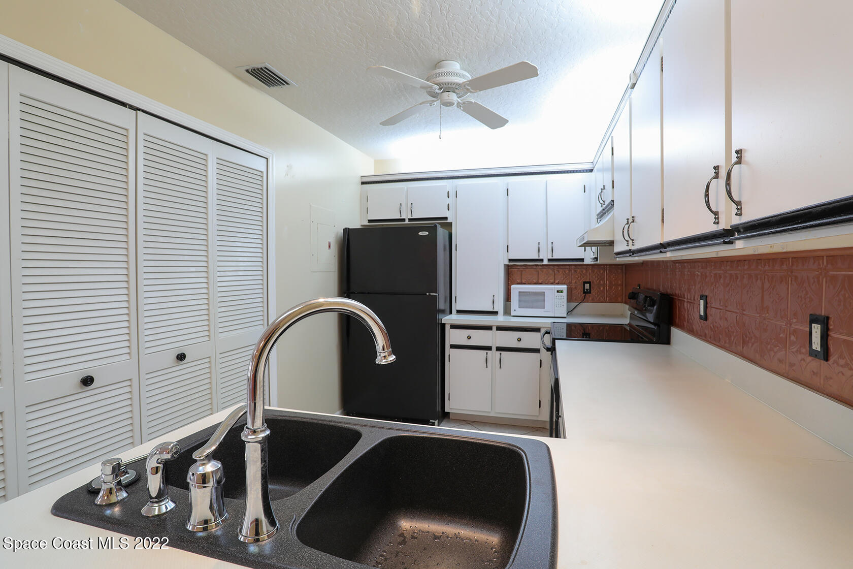 1943 Quail Ridge Court, Unit 604 Cocoa, FL 32926 - Photo 11 of 38 a kitchen with a refrigerator and a sink