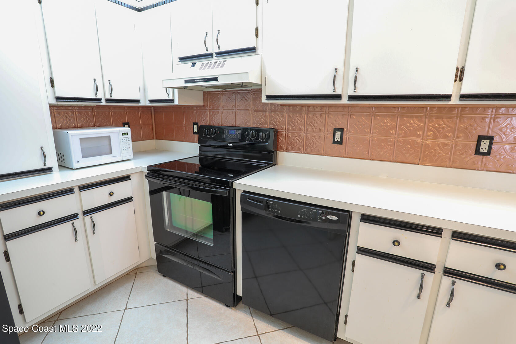 1943 Quail Ridge Court, Unit 604 Cocoa, FL 32926 - Photo 12 of 38 a kitchen with stainless steel appliances cabinets and wooden floor